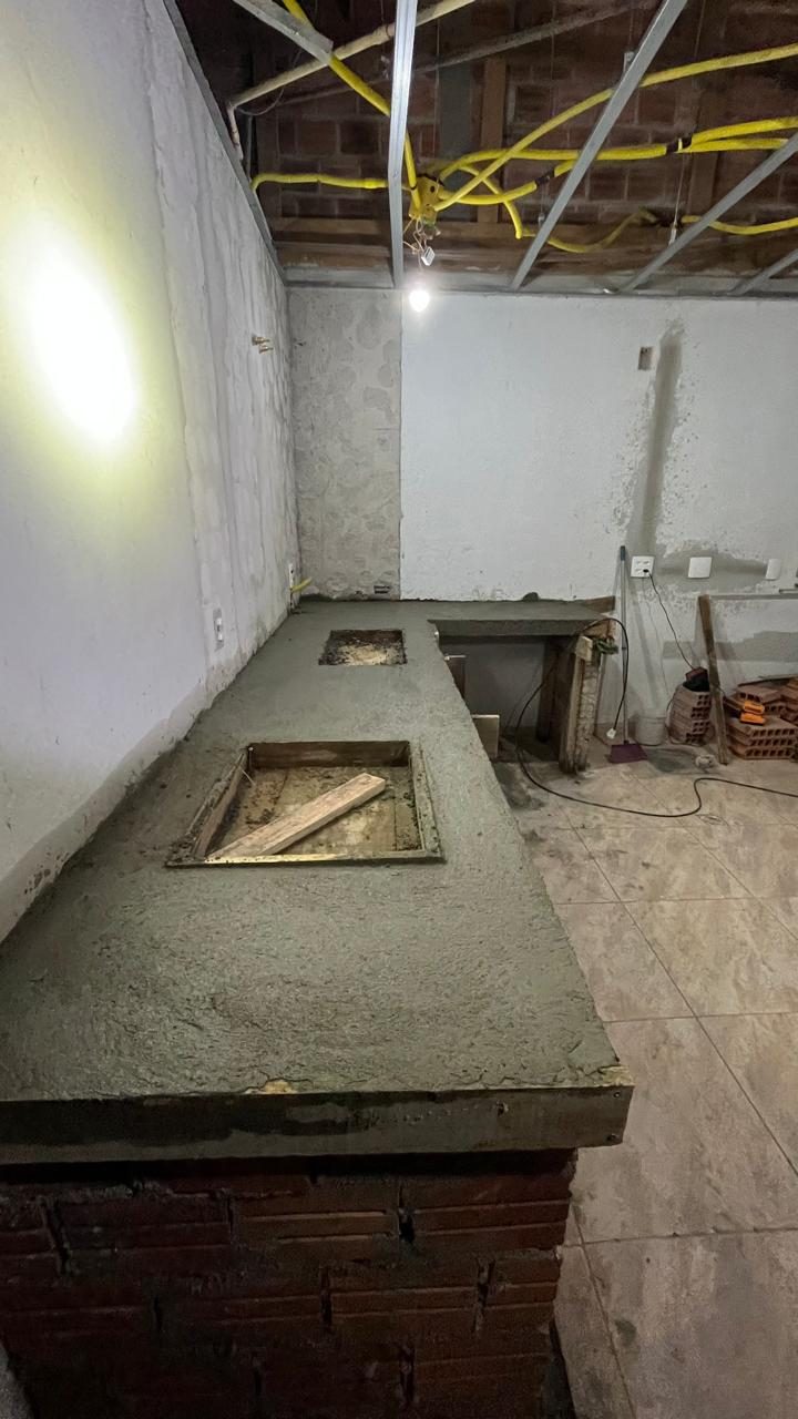 Bancada de tijolo com tampo de concreto e vãos abertos