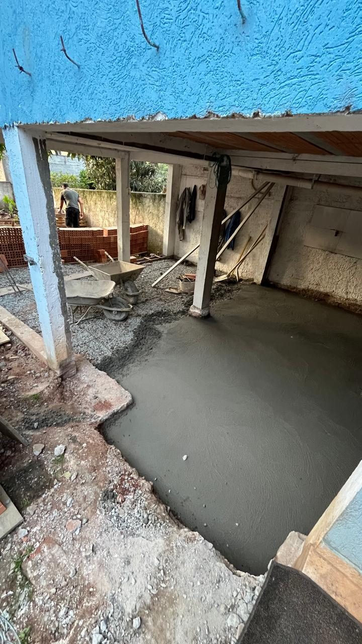 Piso novo concretado em nível mais baixo, entre os pilares da casa